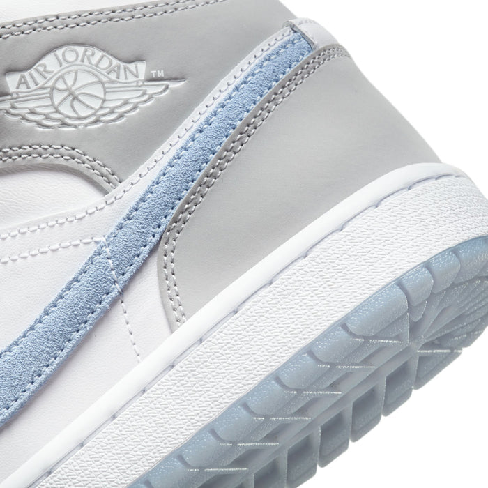 Close-up of Air Jordan wing logo and light blue strap on light gray mid-top sneakers