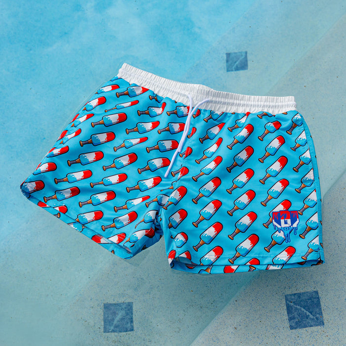BL101 popsicle bat print swim trunks laid flat on a pool deck, showing the full red, white, and blue all-over pattern and white waistband.