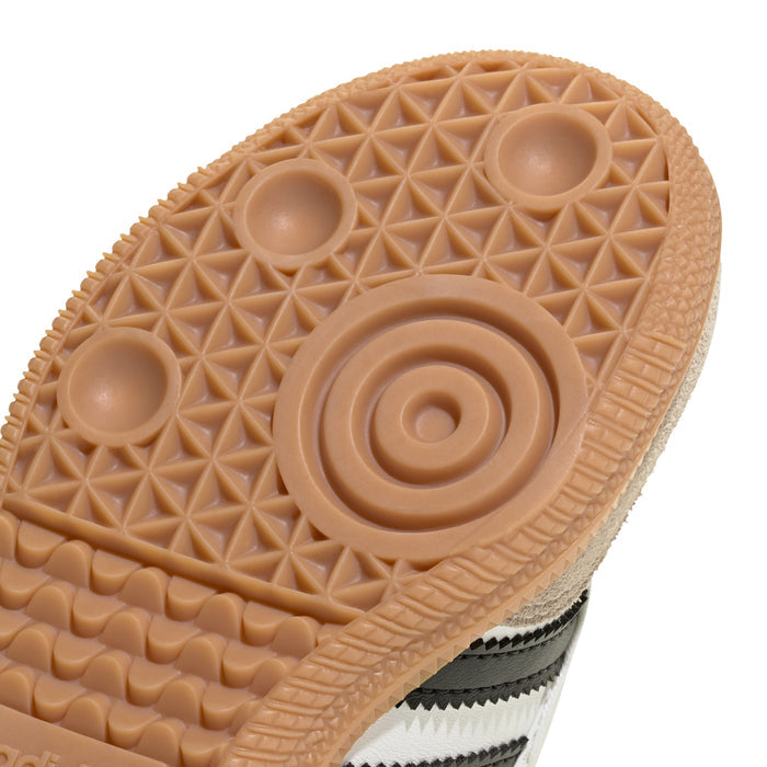 Kids sneaker bottom view showing gum tread texture and grip traction dots