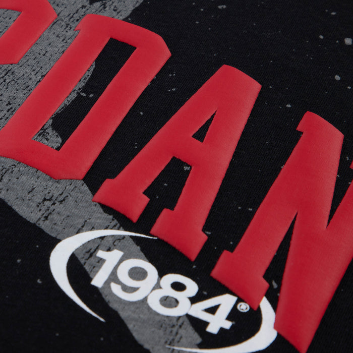 Youth black T-shirt close-up: red Jordan text and white Jumpman 1984 mark
