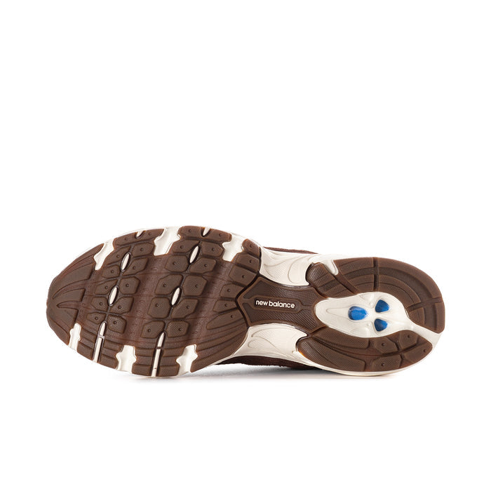 Women’s sneaker outsole with dark tread and New Balance logo in white with blue accent.