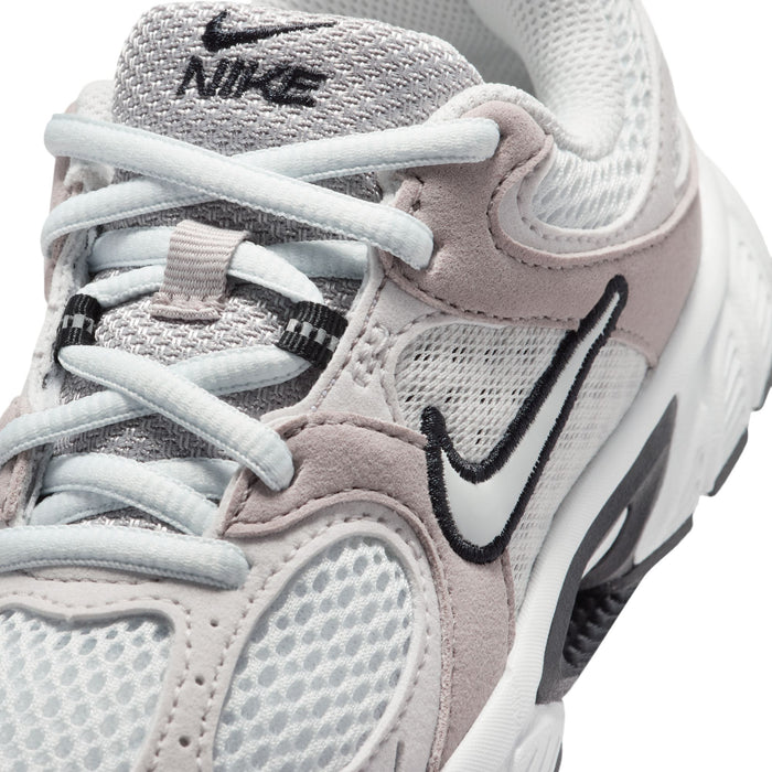 Kids shoe upper close-up with Nike swoosh, mesh panels, and lace eyelets