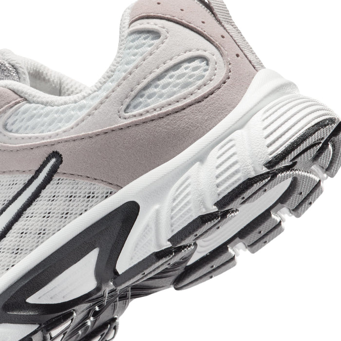 Kids sneaker sole and side close-up with textured tread and swoosh accents