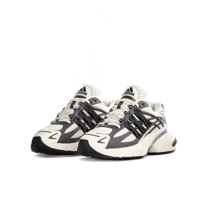 Youth adidas sneakers with cream uppers, black cage overlay, and chunky outsole.