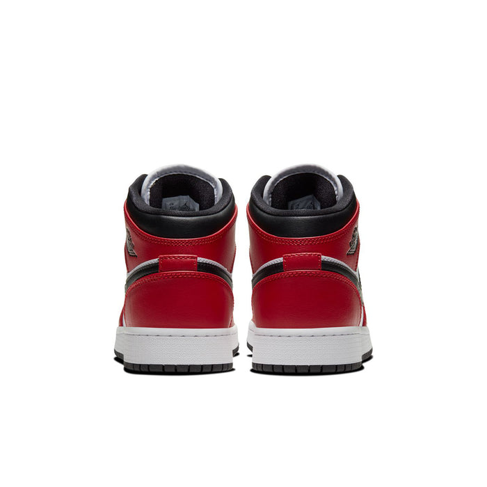 Youth mid-top sneakers with red heel panels, black collar, and white/black outsole detailing
