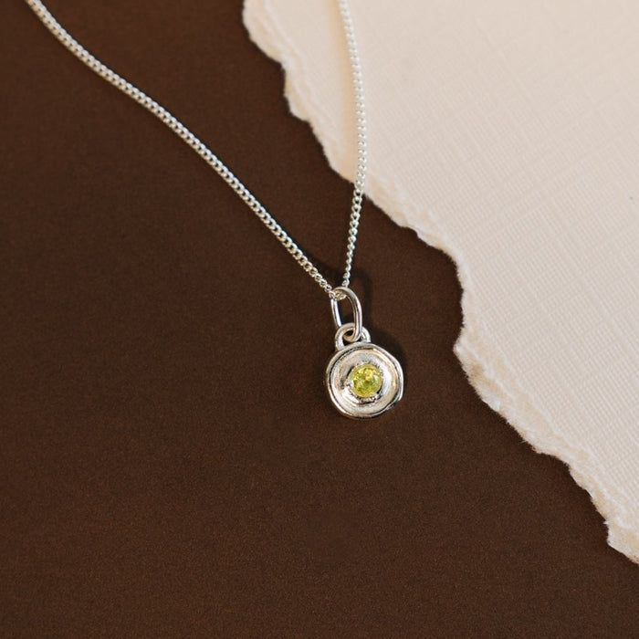 silver necklace featuring a fresh green peridot birthstone pendant with a polished finish