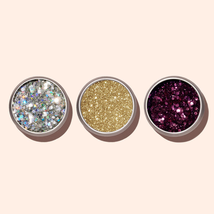 Three round Manucurist Bordeaux Biodegradable Glitter containers—silver, gold, and dark purple—are arranged side by side on a light background, perfect for enhancing gel polish or nail lacquer looks.