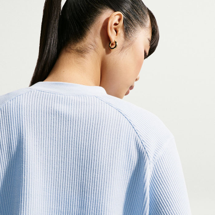 Women’s light blue knit henley top close-up, textured fabric on back