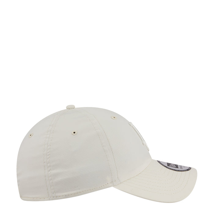 Cream strapback baseball cap, curved brim and side panel stitching