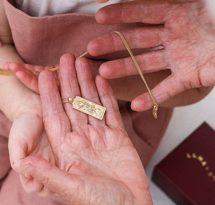 a woman holding Freyja Goddess of Love Pendant  gold