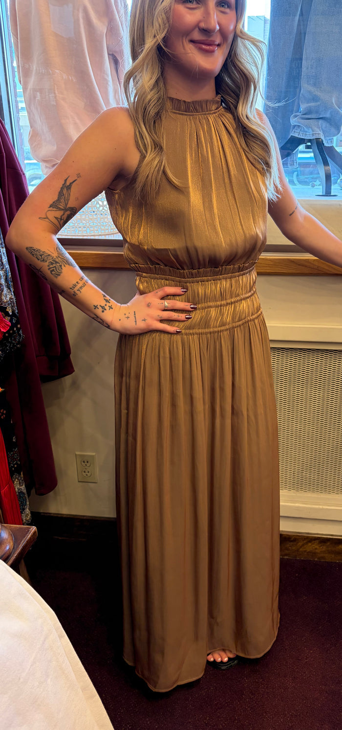 Golden silk halter dress by Current Air, featuring a flowing design and elegant halter neckline, displayed on a dress form.