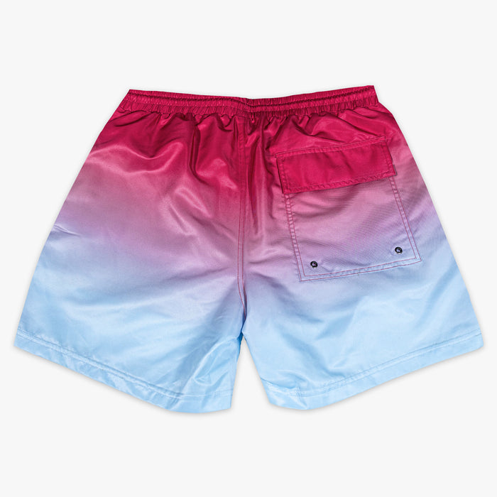 Back flat lay of BL101 pink to blue ombre swim trunks showing the cargo-style snap pocket.