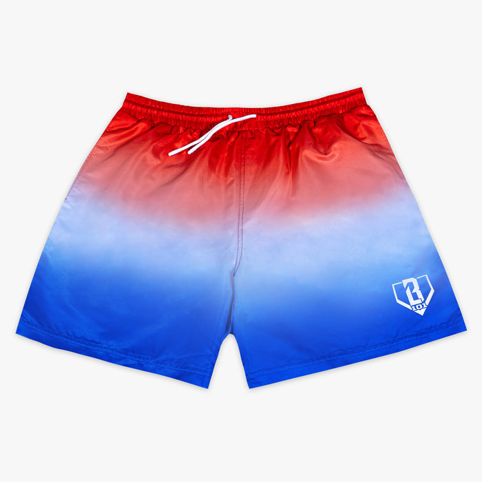 Front flat lay of BL101 red to blue ombre swim trunks with a liner detail inset showing the red baseball stitch trim.