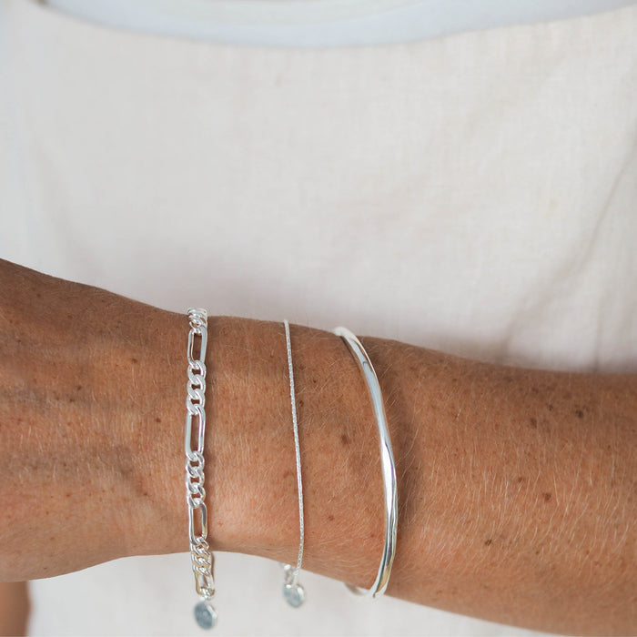 Close-up of a woman's hand wearing e silver bracelets.