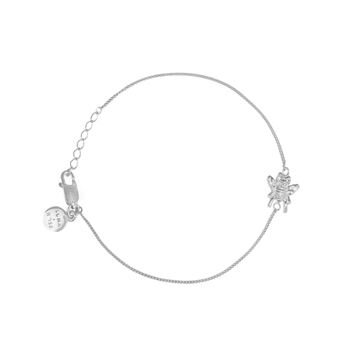 Silver bracelet with two charms on a white background