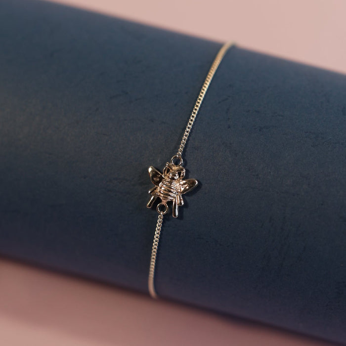 Delicate silver bracelet on a blue and pink gradient background
