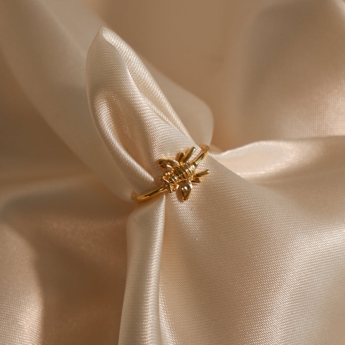 Gold ring with a decorative design on beige fabric