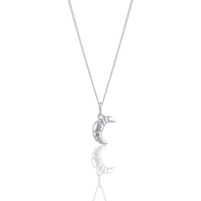 Mini Croissant Necklace in Silver from the ACME x Luna & Rose collection, a delicate croissant-shaped pendant perfect for layering or wearing solo.