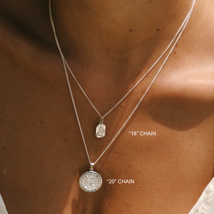 Two silver necklaces with chain lengths labeled on a person's neck.