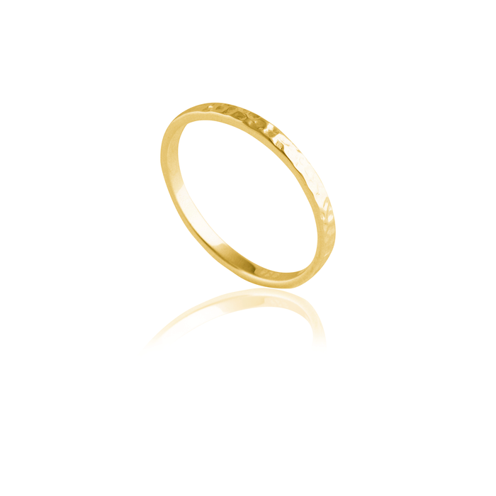 A gold hammered ring isolated on a white background with a reflection.