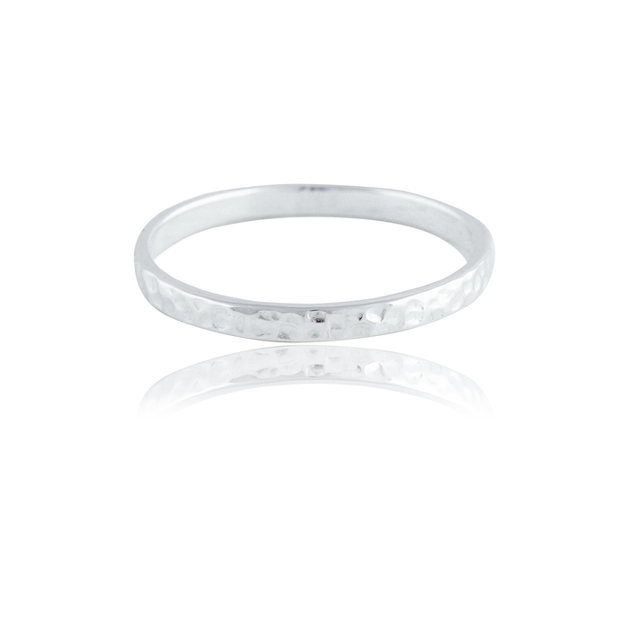 A single narrow, silver  hammered ring isolated on a white background with a reflection.