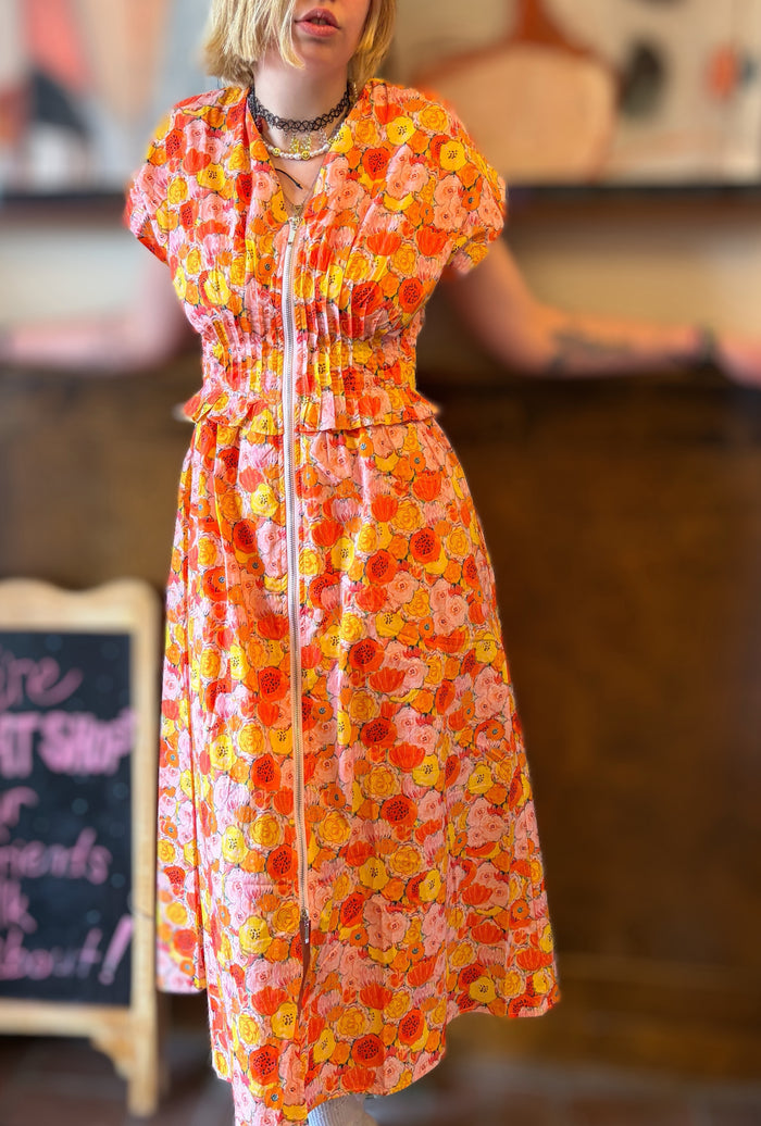 Entro Poppies Dress displayed flat with floral pattern, showcasing vibrant colors and elegant design.