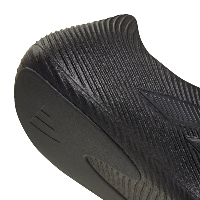 Men's slip-on sport shoe heel close-up, dark black sole with traction grooves