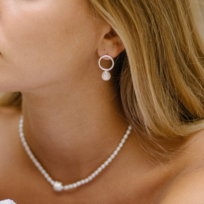 a woman worn pearly silver necklace and silver pearl earrings
