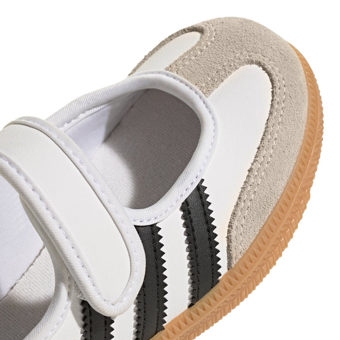 Kids sneaker side view with suede overlays, white upper, and black stripes