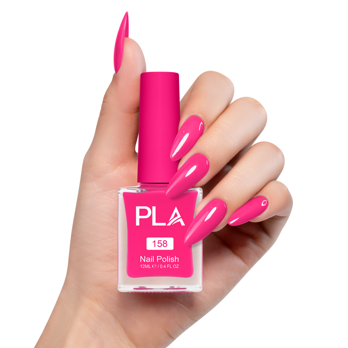Hand holding a pink nail polish bottle with matching nails on a white background
