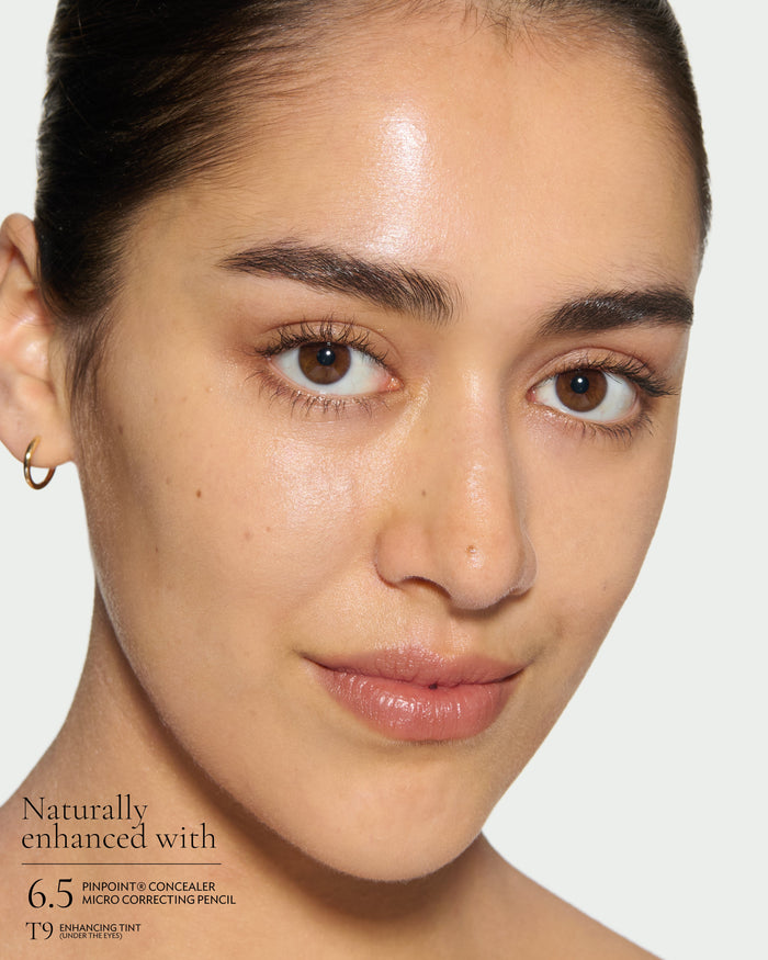 after1 Close-up of a model's face with Pinpoint Concealer and Enhancing Tint on a plain background with text: Naturall Enhanced with Pinpoint Consealer micro correcting pencil and Enhancing Tint (Under the eyes)