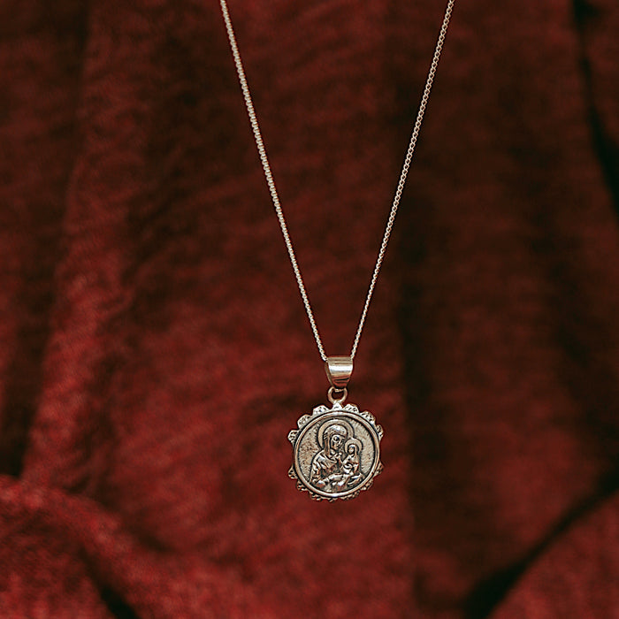 St anne sterling silver necklace on a red backdrop