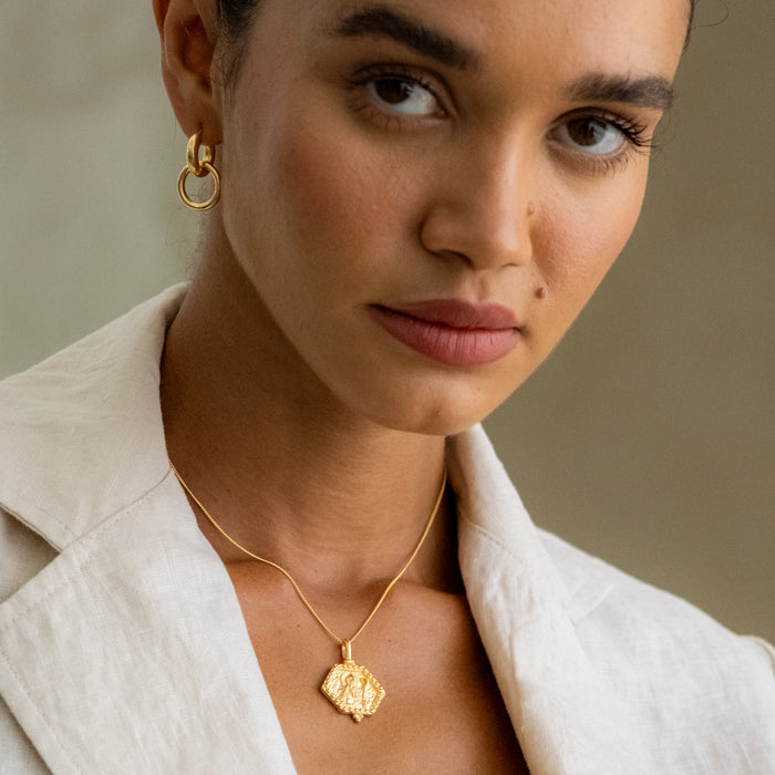 a woman wearing St Benedict necklace gold and Amalfi  earrings gold
