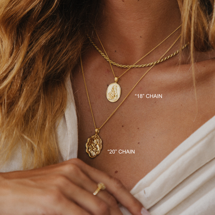 Close-up of a person wearing two gold necklaces with chain lengths labeled.