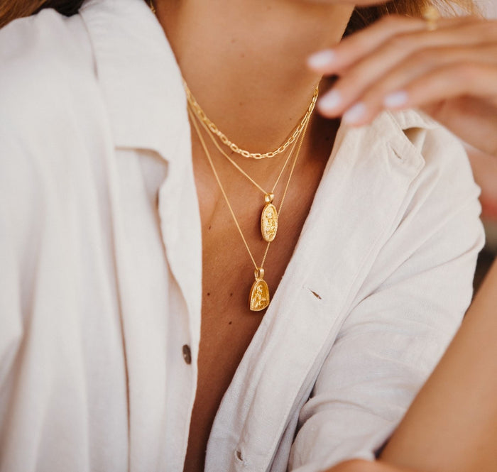 Close-up of a person wearing gold necklaces with a blurred background