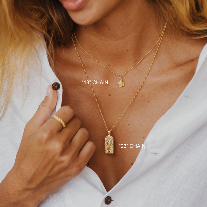 Close-up of a person wearing two gold necklaces with visible chain lengths.