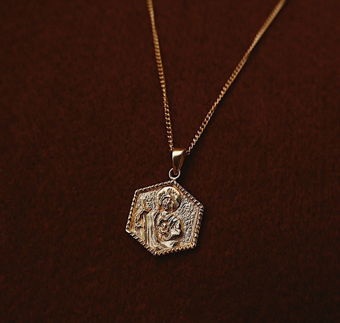 St Jude necklace gold flat lay in red fabric