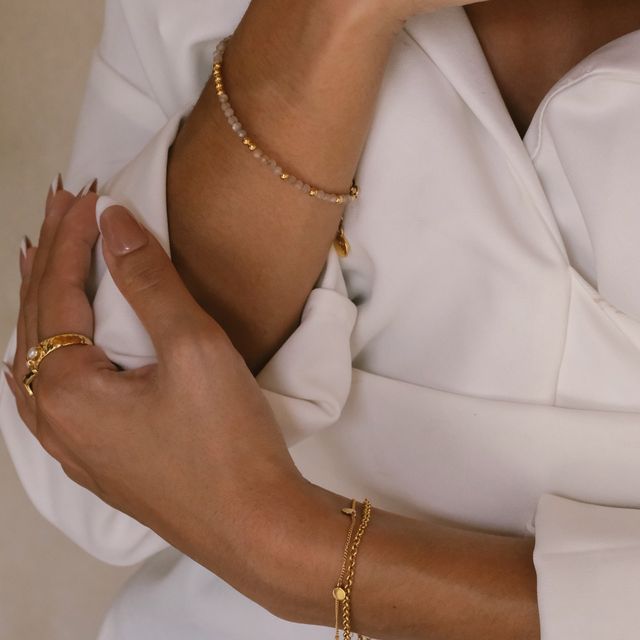 a woman worn multiple bracelet and rings gold on her