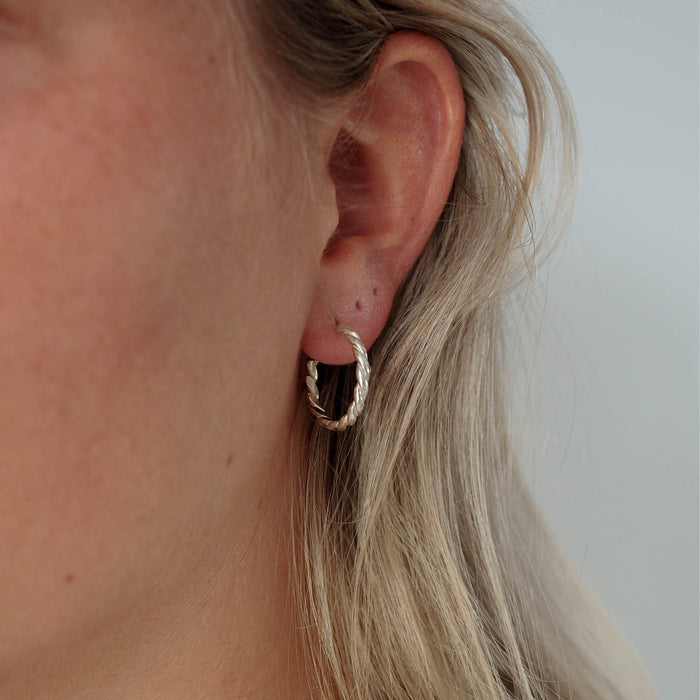 a woman with blonde hair wearing  hoops earring