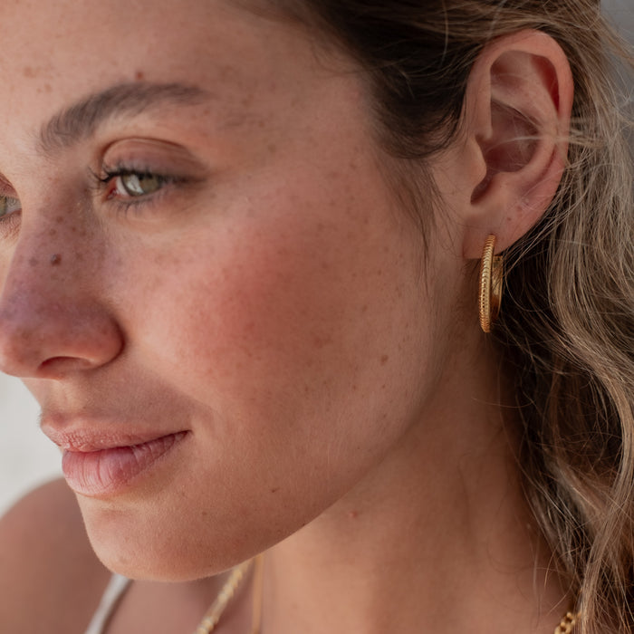 The MET Stripe Thin Earrings 23mm - Gold on woman with blonde hair