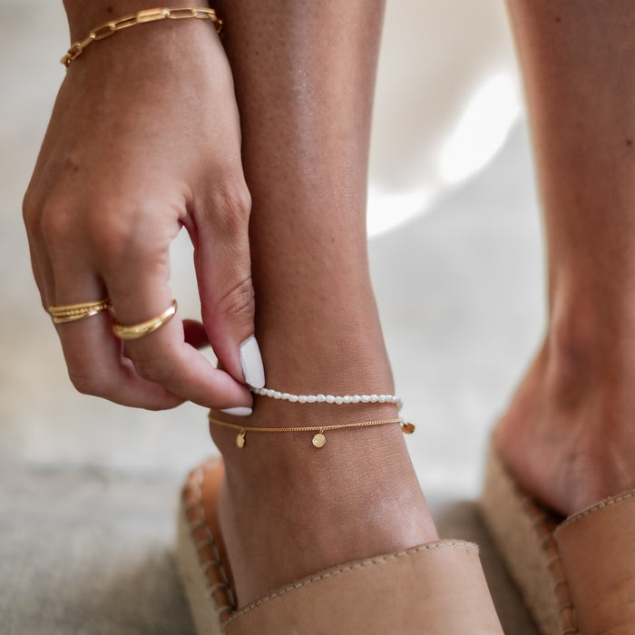a woman wearing multiple jewelry gold on her