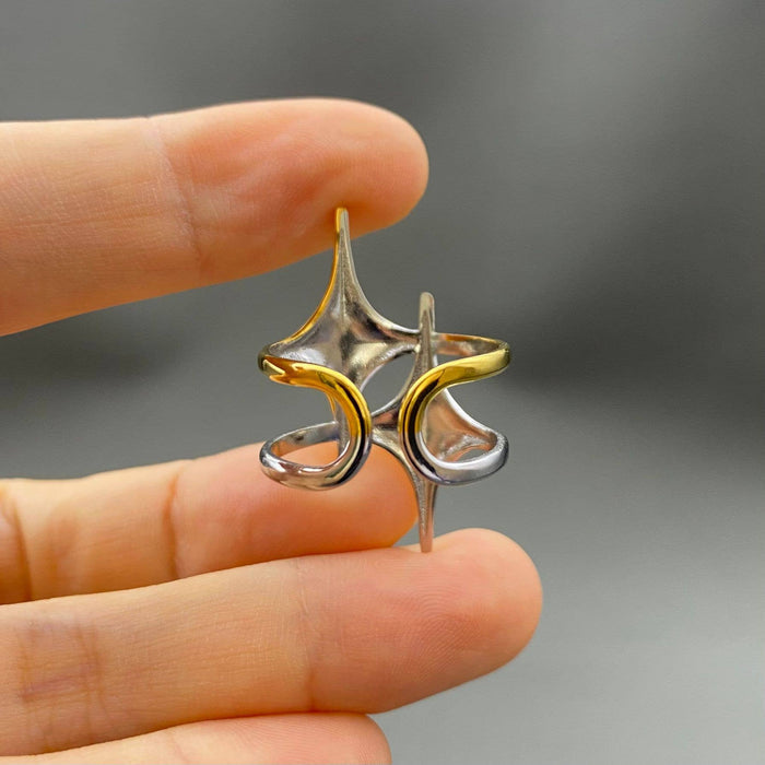 Two-tone double star ring by Mio Queena featuring two intertwined star-shaped bands in silver and gold tones.