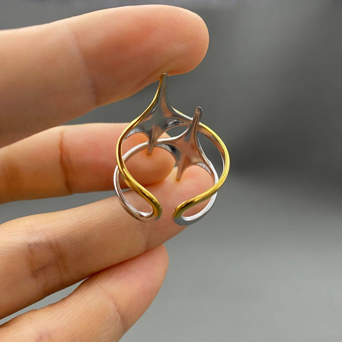 Mio Queena two-tone double star ring with layered design, featuring silver and gold-tone finishes, on a plain background.