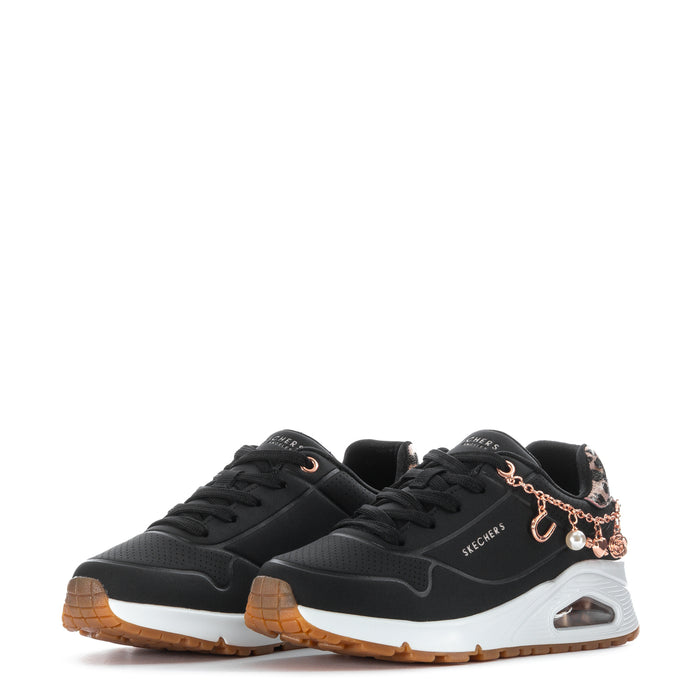 Kids black low-top sneakers, two-shoe view, rose-gold charm bracelet chain and leopard accents