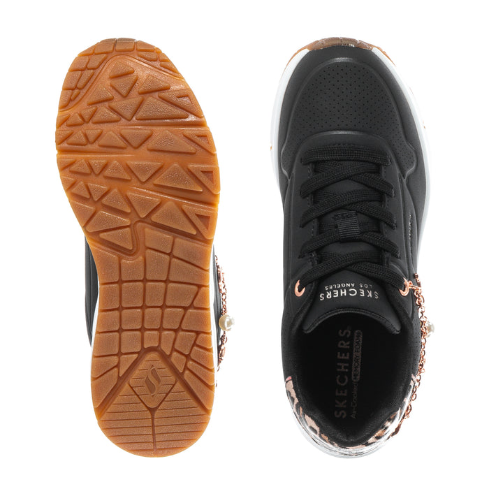 Kids black sneaker outsole and heel view with tread sole and rose-gold charm chain detailing