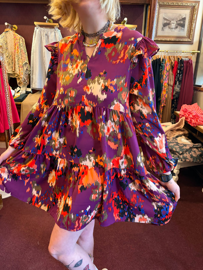 V-neck tiered mini dress by Anniewear featuring flowy fabric and layered design, displayed on a hanger.