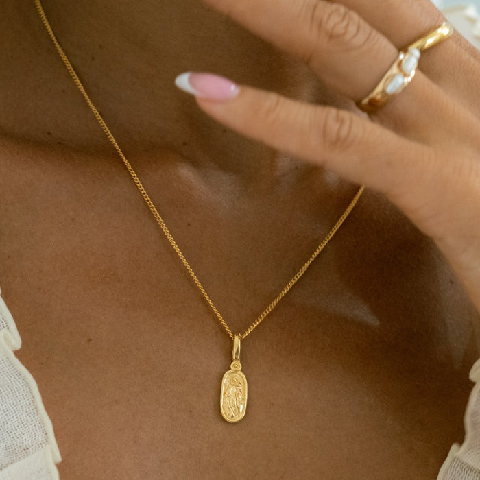 a woman wearing Virgin Mary necklace