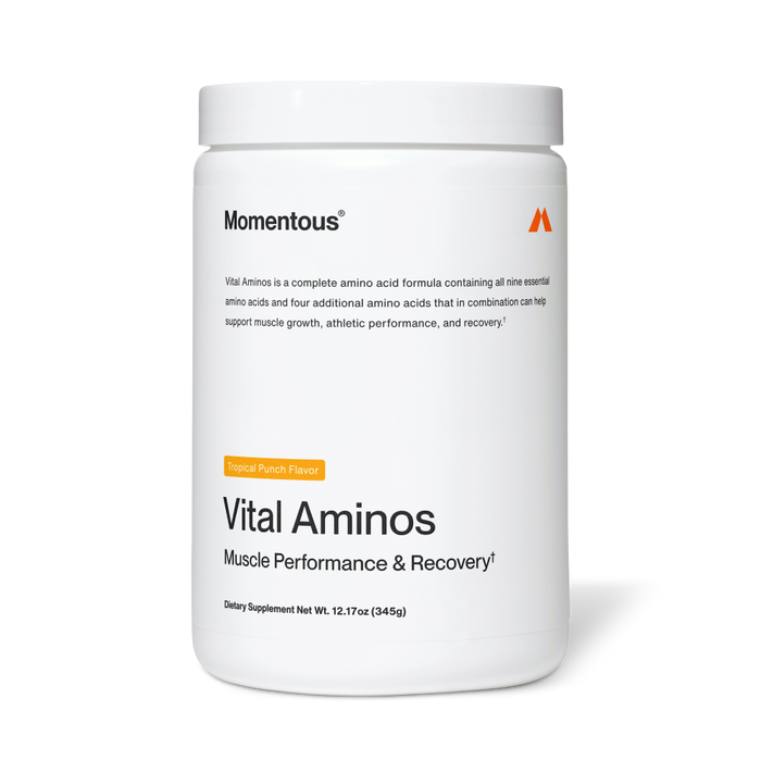 White container labeled “Momentous Vital Aminos – Muscle Performance & Recovery†.” Text notes it is a complete amino acid formula containing all nine essential amino acids plus four additional amino acids to support muscle growth, athletic performance, and recovery. Tropical Punch flavor. Net weight 12.17 oz (345 g).