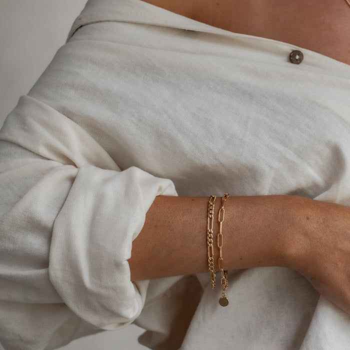 a woman with white shirt  wearing Washington paperclip bracelet gold and Minimalist figari bracelet gold